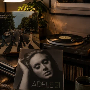 A turntable beside an Adele 21 album sleeve and vinyl records