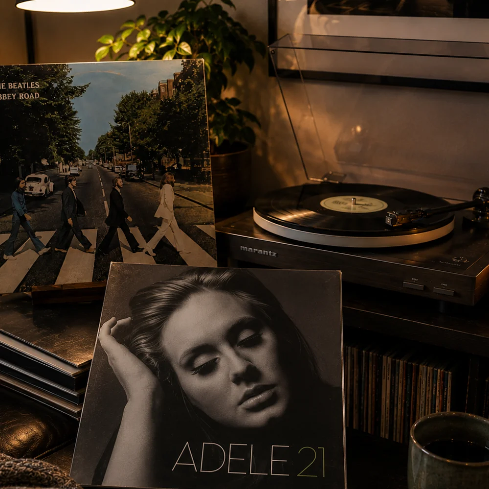 A turntable beside an Adele 21 album sleeve and vinyl records